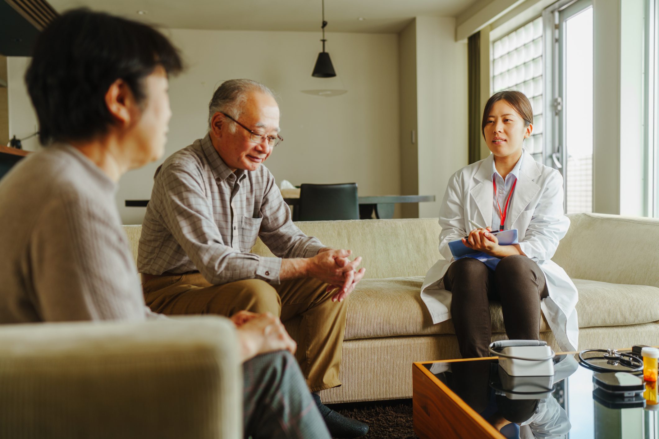 Doctor consulting elderly couple in living room