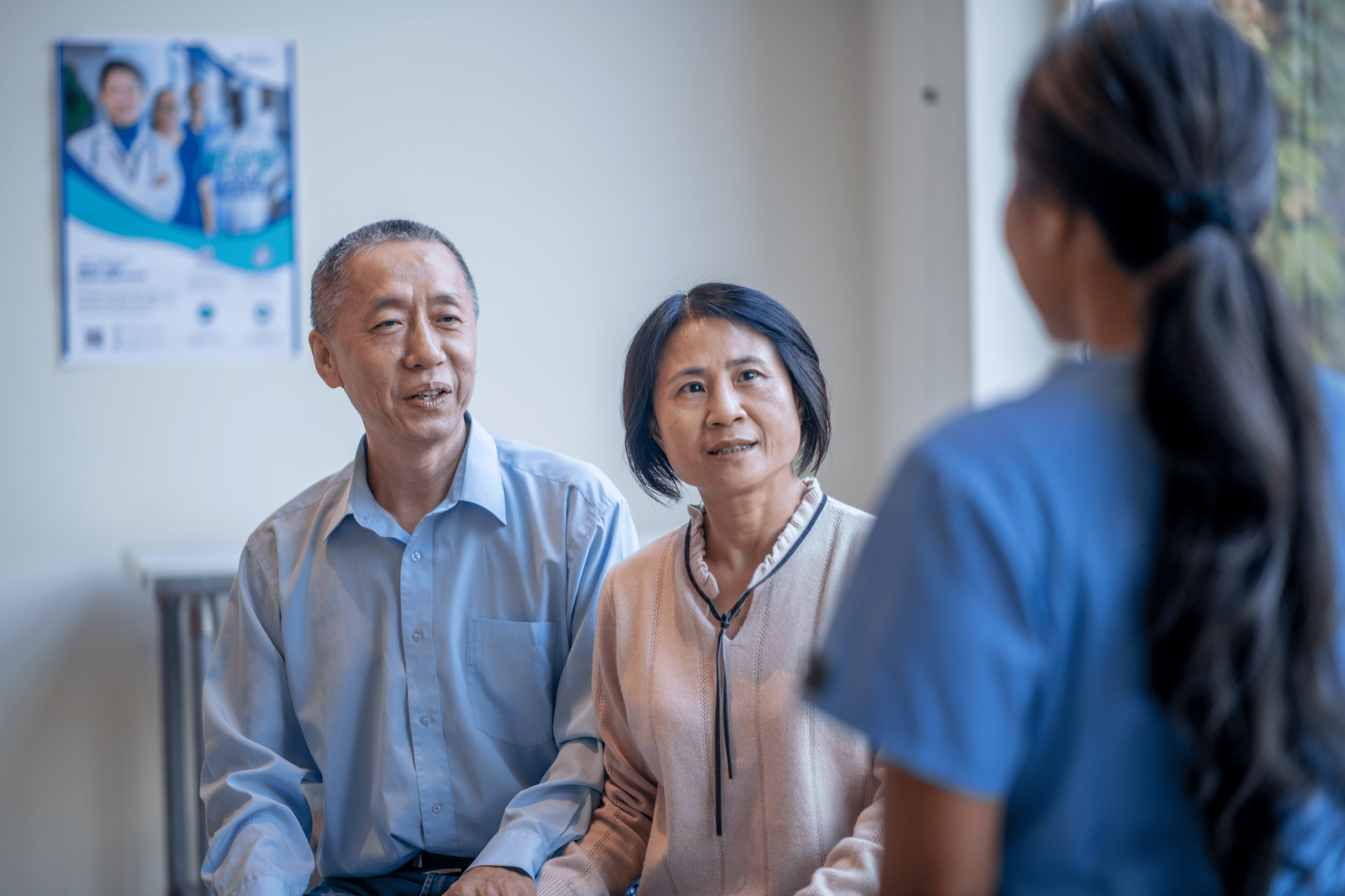 Older couple consulting female nurse in clinic
