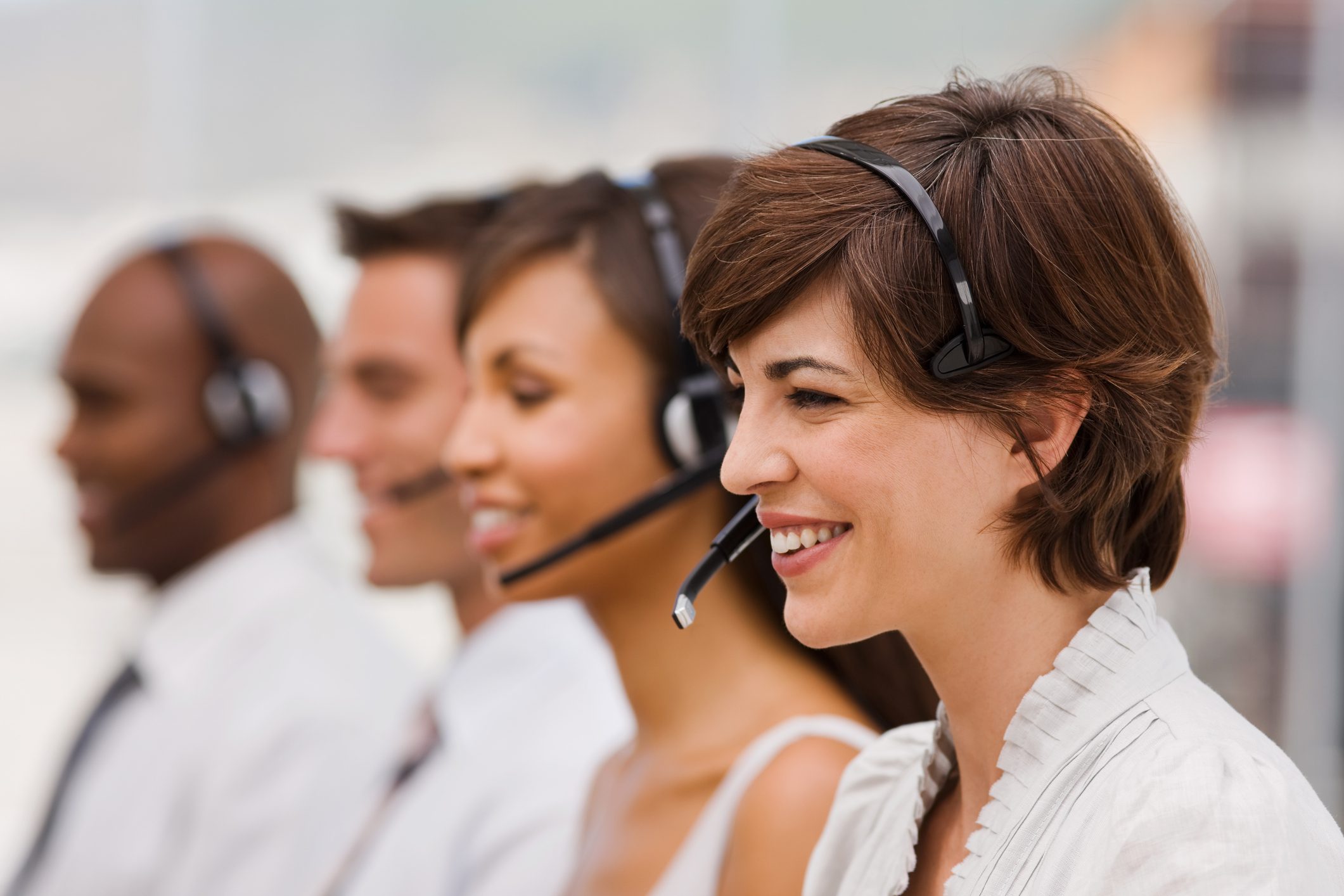 Smiling customer service team wearing headsets