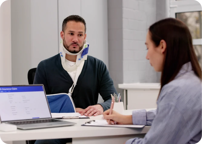 Injured man discussing insurance claim with agent.
